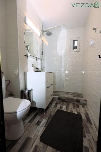 a bathroom with a toilet and a sink and a mirror at Vezda 19 in Orşova