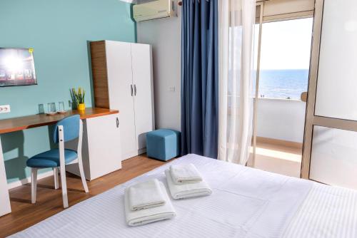 sypialnia z łóżkiem, stołem i biurkiem w obiekcie Hotel Vila MAX w Durrës