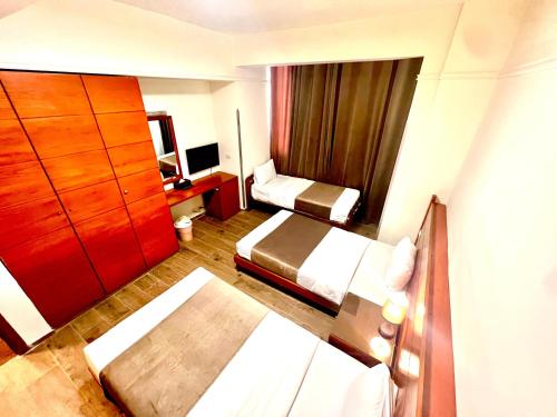 a hotel room with two beds and a dresser at Caesar's Park Hotel in Beirut