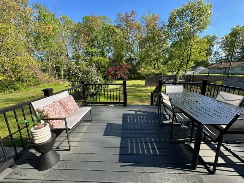 a deck with a bench and a table and a table at Charming Connecticut Hideaway in Middlefield
