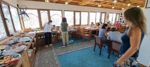 a group of people sitting at tables in a restaurant at Hotel Ansi Boutique W&S terrace in Bukhara