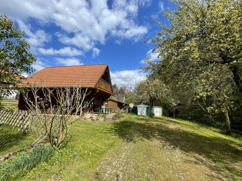 a barn with a red roof on a grass field at Garten Eden in Frohburg