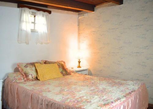 una camera da letto con un letto con un cuscino giallo sopra di Botánica! Casa restaurada a Villa Ballester