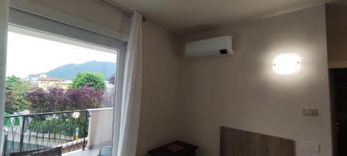 a room with a large window and a balcony at Appartamenti Del Borgo in Borgosesia