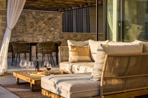 a patio with a couch and a table with wine glasses at SalvatoreHomes - Pure Luxury in the Centre of Bardolino with Pool & Private Garden - Casa Olivia - a 5 Star Luxury Collection at Lake Garda in Bardolino