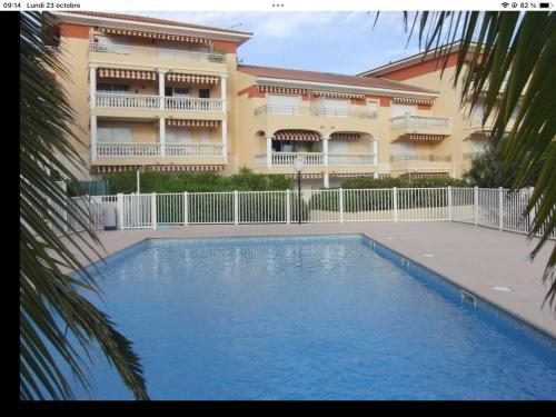 un immeuble avec une piscine devant un immeuble dans l'établissement Bord de mer, à Saint-Raphaël
