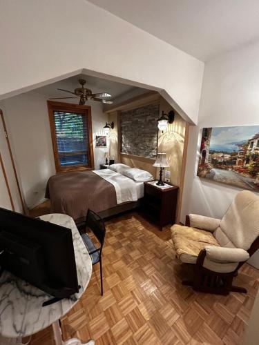 a bedroom with a bed and a tv and a couch at Gite Le Sieur de Joliette in Montréal