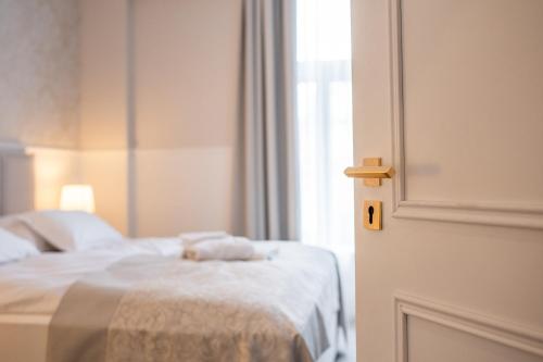 a bedroom with a bed and a open door at GRAND CENTRAL LJUTOMER in Ljutomer