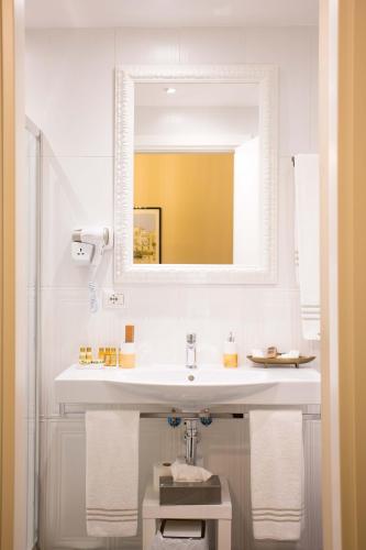 a white bathroom with a sink and a mirror at DOMUS DEORUM in Naples