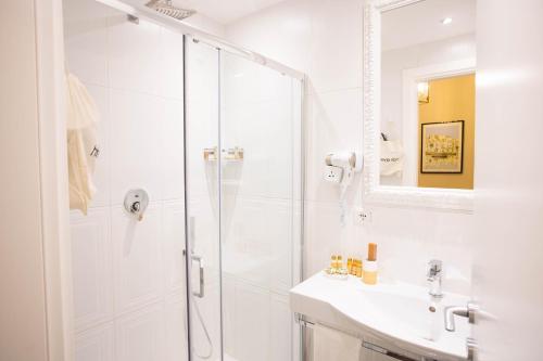 a white bathroom with a shower and a sink at DOMUS DEORUM in Naples