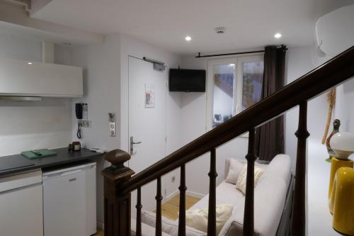 a living room with a staircase and a kitchen at Hotel Albert 1er in Toulouse