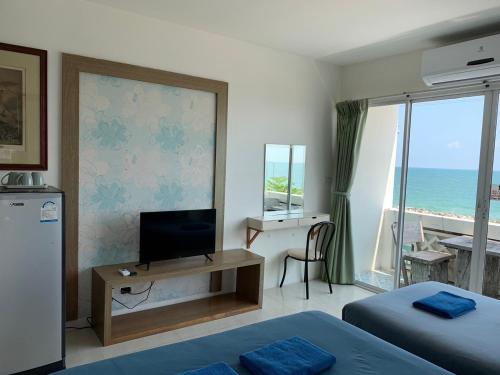 a room with two beds and a flat screen tv at Banchaitalay Room in Rayong