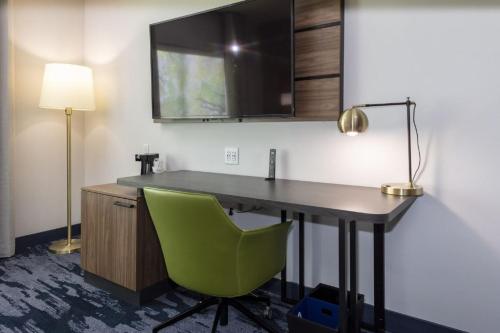 - biurko z zielonym krzesłem w pokoju w obiekcie Fairfield Inn & Suites Monahans w mieście Monahans