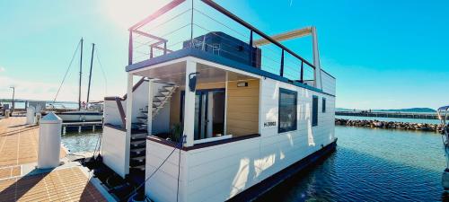 ein Hausboot, das an einem Dock im Wasser angedockt ist in der Unterkunft Fenyves Yacht Club Superior in Balatonfenyves