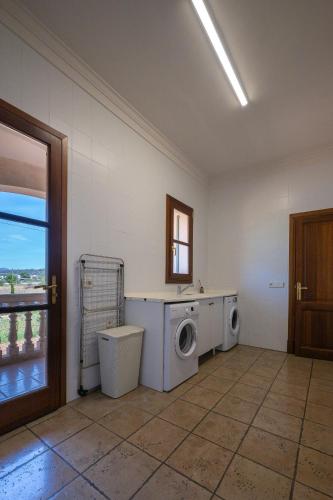 a laundry room with two washing machines and a window at FINCA MANACOR in Manacor