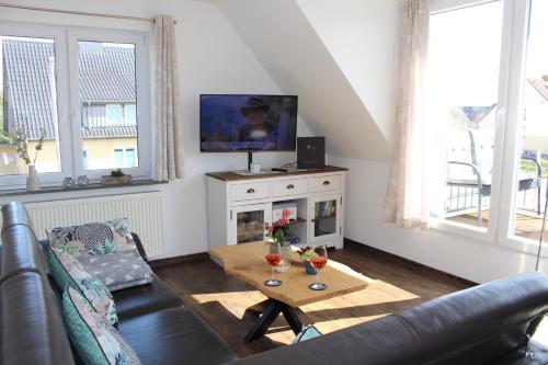 a living room with a couch and a tv at Haus Deutsche Bucht in Borkum