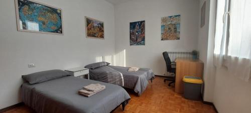 Habitación pequeña con 2 camas y escritorio. en Camera LOW COST in alloggio condiviso Stanza 1 en Crema