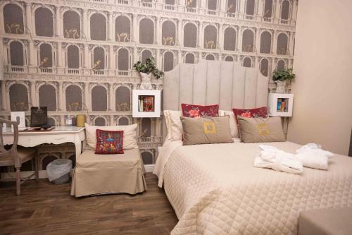 a bedroom with two beds and a desk at Domus Deorum Deluxe in Naples