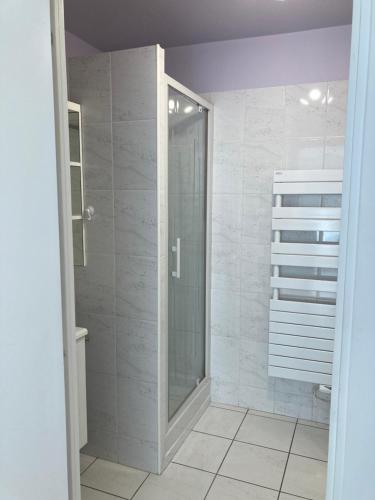 une salle de bain avec une douche à l'italienne et une porte vitrée dans l'établissement Bord de mer, à Saint-Raphaël