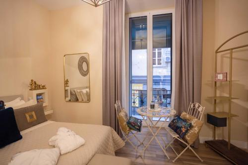 a bedroom with a bed and a table and a window at Domus Deorum Deluxe in Naples