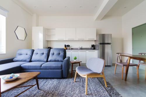 a living room with a blue couch and a table at Franklin Suites South Beach in Miami Beach