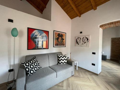 una sala de estar con sofá y algunas fotos en la pared en Luxuria en Iglesias