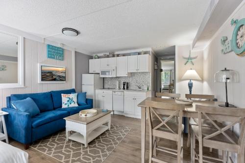 ein Wohnzimmer mit einem blauen Sofa und einer Küche in der Unterkunft Beachcomber Resort in Avalon