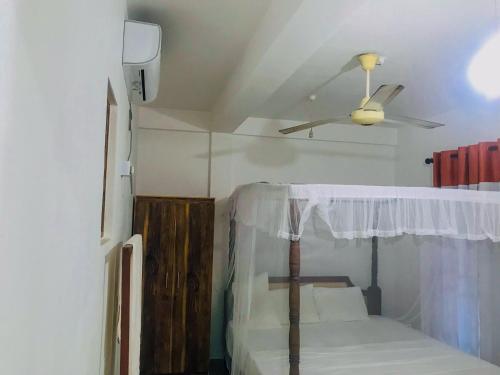 a room with a bed with a ceiling fan at Lake View Villa - Tangalle in Tangalle