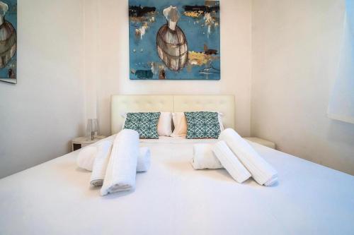 - un lit blanc avec des oreillers blancs et un tableau dans l'établissement Villa Giada, à Francavilla Fontana