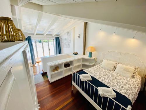 Almocabar Luxury Apartment في روندا: غرفة نوم بيضاء مع سرير ومكتب