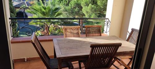 d'une table et de chaises en bois sur un balcon avec vue. dans l'établissement Appartement T3 Marine de Bravone proche mer, à Linguizzetta