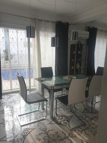 una sala da pranzo con tavolo in vetro e sedie di lemsa a Draria
