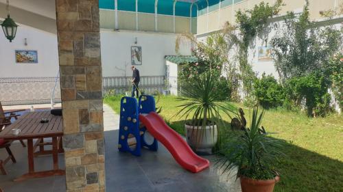 a patio with a playground with a slide and a table at lemsa in Draria