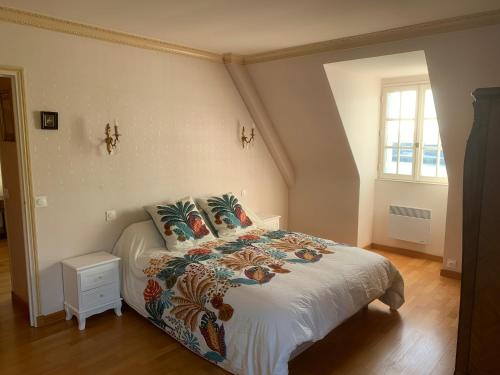 a bedroom with a bed with a white comforter at Maison vue mer baie de Saint Brieuc in Plérin