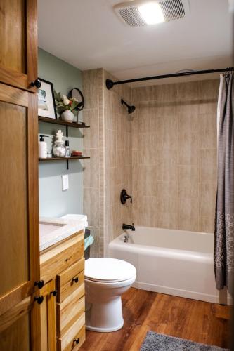 a bathroom with a tub and a toilet and a sink at Charming Cabin with Hot Tub & Fire Pit in Pepin