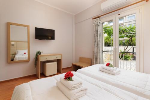 Habitación blanca con 2 camas y espejo. en Santos Luxury Apartments en Dassia