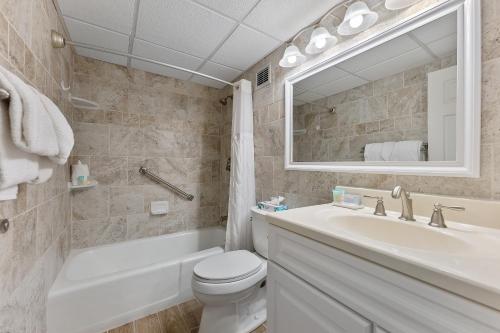 a bathroom with a sink toilet and a mirror at Beachcomber Resort in Avalon
