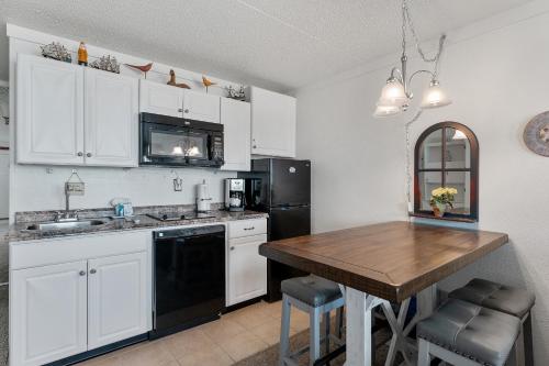 a kitchen with white cabinets and a wooden table at Beachcomber Resort in Avalon