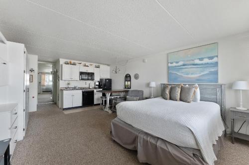 a bedroom with a white bed and a kitchen at Beachcomber Resort in Avalon