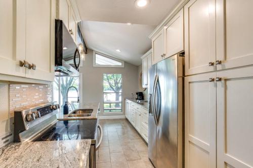 a kitchen with white cabinets and a stainless steel refrigerator at Private Dock and Fire Pit Cedar Creek Reservoir Gem in Gun Barrel City
