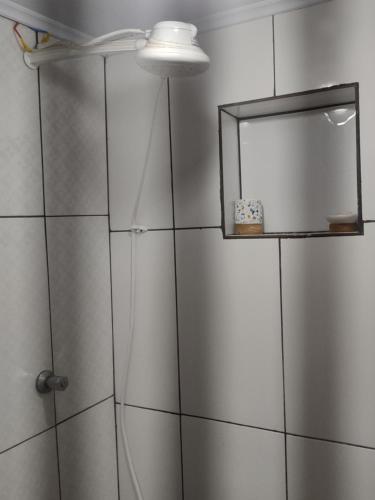 ein Bad mit einer Dusche und einem Spiegel in der Unterkunft AP da Cris cabo frio in Cabo Frio