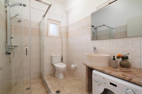 y baño con ducha, aseo y lavamanos. en Santos Luxury Apartments en Dassia