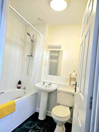 a white bathroom with a toilet and a sink at Beautiful Townhouse with Netflix in Long Eaton