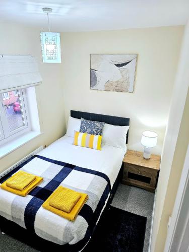 a bedroom with a bed with a striped blanket at Beautiful Townhouse with Netflix in Long Eaton