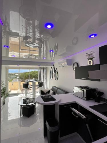 une cuisine avec des lumières violettes sur les murs dans l'établissement Portnature 571 Cap d'Agde Naturiste, au Cap d'Agde