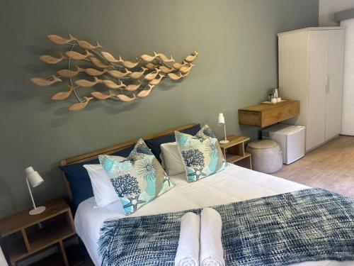 1 dormitorio con 1 cama con almohadas azules y blancas en Beachfront Bliss en Wilderness
