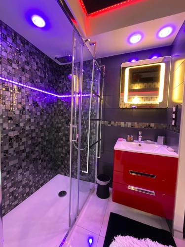 La salle de bains est pourvue d'un lavabo rouge et d'une douche. dans l'établissement Portnature 571 Cap d'Agde Naturiste, au Cap d'Agde