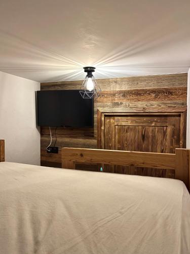 une chambre avec un lit et une télévision à écran plat dans l'établissement Appartement de standing 8 au pied des pistes - OLVERA 202, à Valmeinier