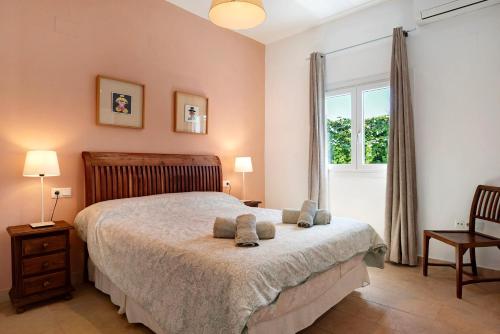 a bedroom with a bed and a window at Villa Amura - Solo Familias in Conil de la Frontera
