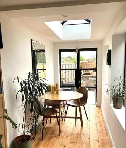 a dining room with a table and some plants at Our beautifully renovated home in Chichester